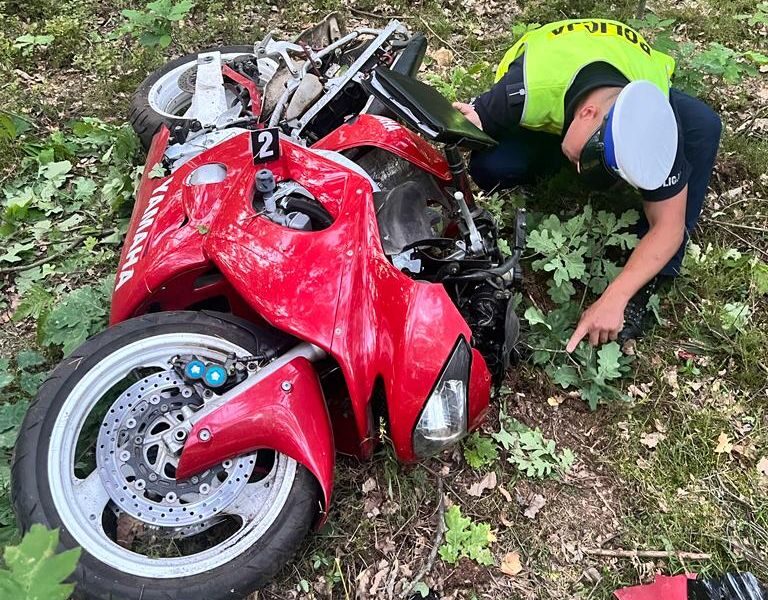 Policjant oglądający motocykl po śmiertelnym wypadku Fot. Policka