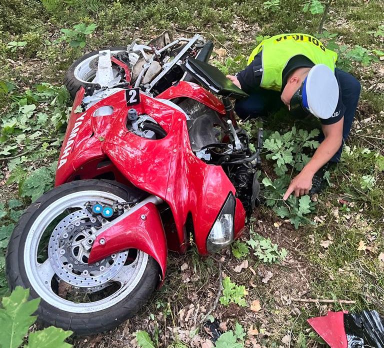 Policjant oglądający motocykl po śmiertelnym wypadku Fot. Policka